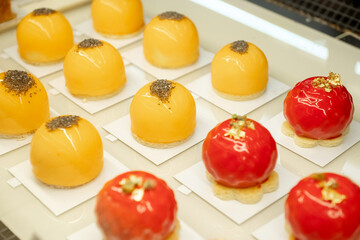 Eat an Extra Dessert Day Colorful round pastries with red and orange glossy glaze, gold leaf, and decorative toppings
