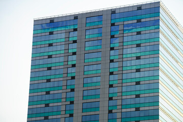 Fototapeta premium Modern Glass Facade of a High-Rise Building Under Clear Sky