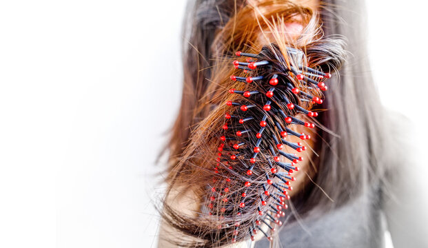 Closeup portrait of female model holding messy hair in hands, Combing with brush and pulls long hair, Daily preparation for looking nice, Long Disheveled Hair, Holding Messy Hair