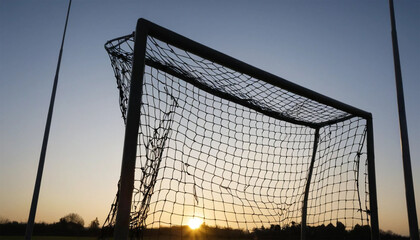 Shadow of a goalpost at sunrise