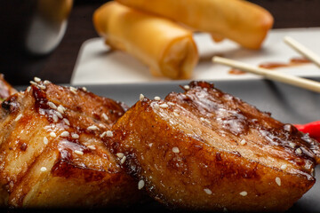 Stewed meat with sesame on a black plate, Japanese cuisine