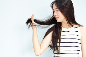 Closeup portrait of female model holding messy hair in hands, Combing with brush and pulls long hair, Daily preparation for looking nice, Long Disheveled Hair, Holding Messy Hair