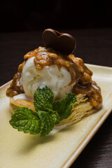 Dessert with puff pastry and ice cream drizzled with caramel on a plate