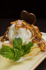 Dessert with puff pastry and ice cream drizzled with caramel on a plate