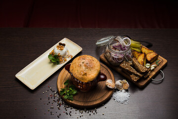 Set of Belarusian cuisine from a pot with herring meat with onions and dessert