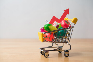 Red arrow growth chart, food, drinks, vegetables, fruits in supermarket trolley. Rising cost of...
