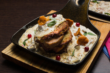 Draniki with chanterelle mushrooms, cream sauce and meat