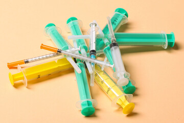 Top view of a heap of syringes and insulin syringes at orange background. Medical injection concept...