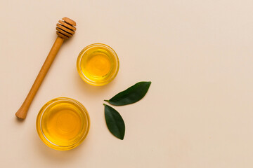 Honey jar with wooden honey dipper on white background top view with copy space. Delicious honey bottle