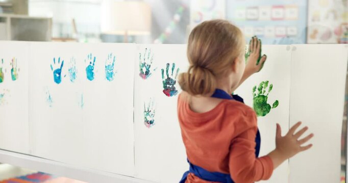 Girl, student and creative for handprint painting of art lesson, identity poster and preschool learning. Back, child and canvas for fun activity, artwork project and color mixing of education memory