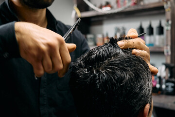 A barber carefully cuts and styles a client's hair in a contemporary barbershop. The atmosphere is lively, with various hair products in the background, reflecting a dedicated space for grooming