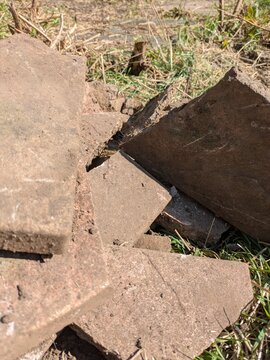 Close up of old broken pation pavement slabs dug up from house garden renovation DIY