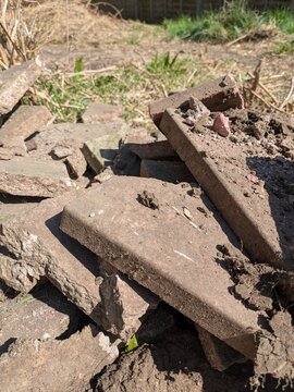Close up of old broken pation pavement slabs dug up from house garden renovation DIY