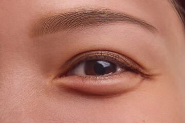 Fototapeta premium Young Asian woman with flawless radiant skin gazes softly with minimalist makeup, perfect for campaigns on facial aesthetics, daily skincare, and healthy beauty habits. Natural female beauty concept