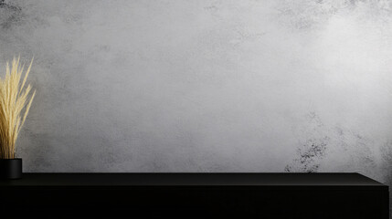 minimalist interior featuring textured gray wall and black surface with decorative grass