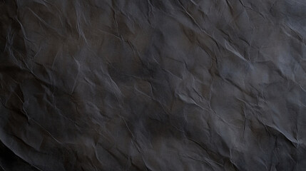 Crumpled black paper texture with deep shadows and subtle variations creates artistic backdrop