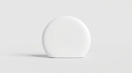 A singular white egg shaped object against a simple background