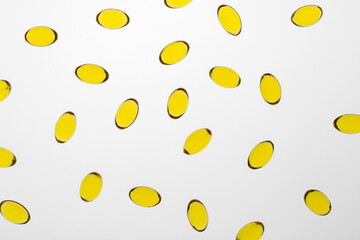 Omega 3 yellow capsules on the white background, supplement and health support concept