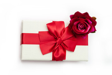 Red rose on gift box on white background.