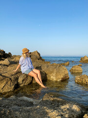 Woman relaxing on rocks by the sea
