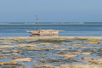 stary katamaran - tradycyjna kenijska łódź rybacka na Oceanie Indyjskim, zacumowana w lagunie u wybrzeżapodsczas odpływu. Okolice Mombasy, Kikambala, Kenia, Afryka © Kamil_k2p