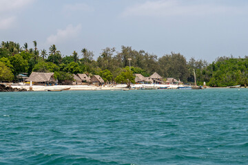 zabudowania przy porośniętej tropikalna roślinnością plaży w Kenii © Kamil_k2p