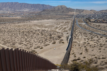 Aerial view of border wall and desert city