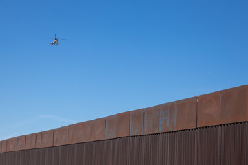 Surveillance helicopter flying over border fence