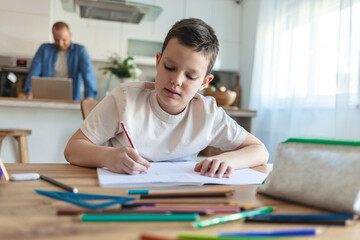 Fototapeta premium Student, drawing or boy writing homework on notebook education for growth development. Project, creative or young kid artist with color pencil learning or working on sketching skills.
