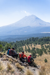 Hikers resting and admiring popocatepetl volcano in mexico