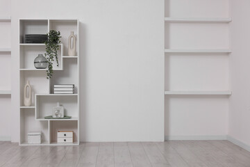 Shelving unit with decor near white wall indoors