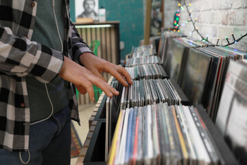 Man choosing vinyl records in store, closeup