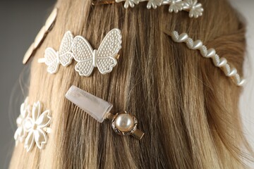 Woman with beautiful hair clips on grey background, closeup