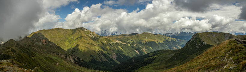 Fototapeta premium vista panoramica ultra ampia su un ambiente naturale di montagna tra le Alpi nel nord Italia, nella regione Friuli Venezia Giulia, di giorno, in estate, con cielo nuvoloso