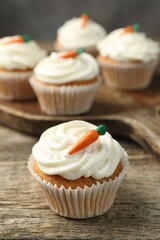 Delicious carrot cupcakes on wooden table, closeup
