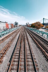 Fototapeta premium High-angle, slow-motion slider shot of a train approaching Broadway Junction, steel tracks gleaming - tracks urban transportation