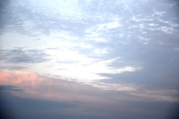 Obraz premium birds are flying in the blue sky to the east, surrounded by clouds near the moon.