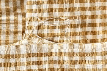Loose fabric from brown colored picnic fabric napkin cloth object isolated on horizontal background.