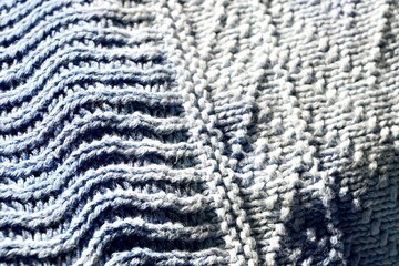 Close up blue colored knit fabric clothing detail isolated on horizontal background.