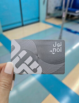 Dubai, United Arab Emirates - April 4, 2025: A woman's hand holding NOL metro card inside Dubai metro train cabin