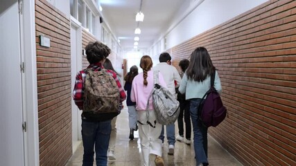 Young students walking together through bright school hallway, sharing moments of carefree friendship and excitement during break time