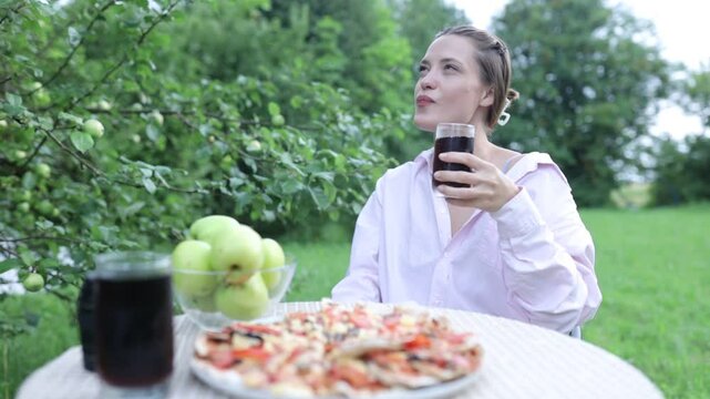a young woman having breakfast in the garden in summer