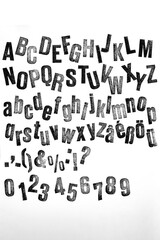 Scattered stamp letters with black ink ,alphabet on white background collection, close up
