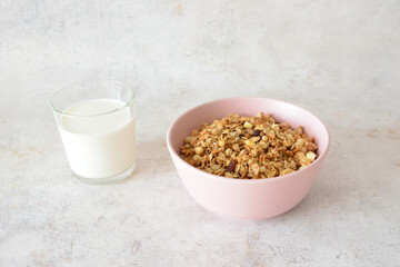 Granola in pink bowl and milk for breakfast