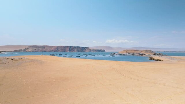 Aerial View of Fishing Boats Anchored in a Pacific Bay near Paracas Peninsula, Peru. This aerial footage captures a peaceful bay along the Pacific coast near the Paracas Peninsula 