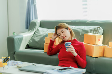 A young woman is relaxing and sipping coffee after brainstorming ideas for an online sales...