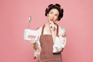 Young minded fun happy cheerful housewife housekeeper chef cook baker woman wears brown apron hold...