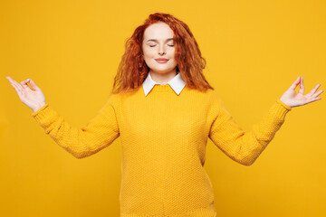 Young redhead woman wear sweater white shirt casual clothes hold spreading hands in yoga om aum...
