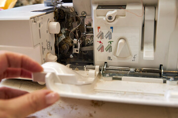 the foreman dusts off the overlock sewing machine