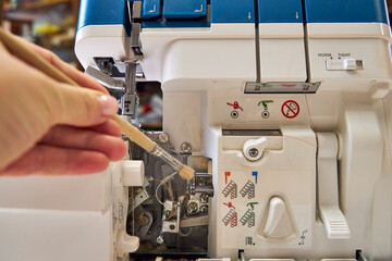 the foreman dusts off the overlock sewing machine